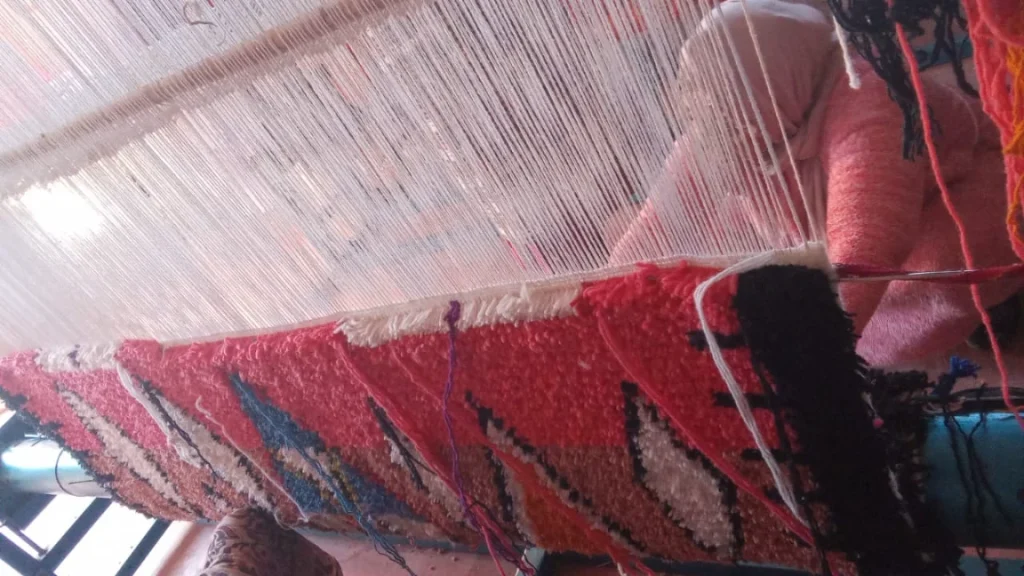 Moroccan rug being handwoven on a traditional loom